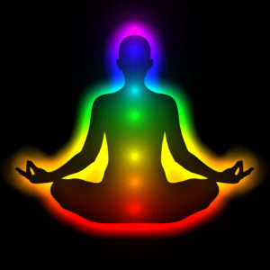 7 chakras glowing in figure in meditation pose