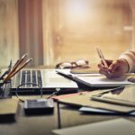 keyboard, pencils, hand writing notes in a book