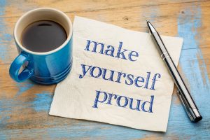 Make yourself proud - handwriting on a napkin with a cup of espresso coffee
