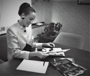 Nancy in a business suit working at a desk before she founded My Persuasive Presentations, LLC