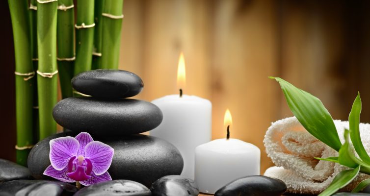 zen basalt stones and orchid with bamboo and white candles on the wood