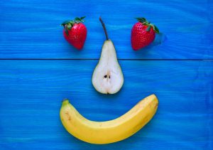 a happy face made of fruit on a blue background