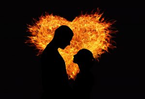 Silhouette of a man and woman facing each other against the background of a heart on fire by Gerd Altmann