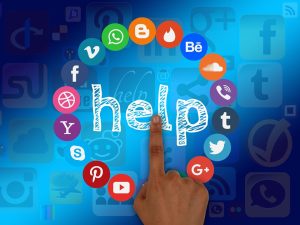A finger points at a circle of social media internet icons and the word "help" in the middle of them. AI can help greatly with content development