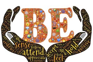 An illustration of two hands holding the word "BE." The hands also have words in them like sense, hold, accept, attend, etc. To depict the Benefits of Mindfulness During Social Unrest